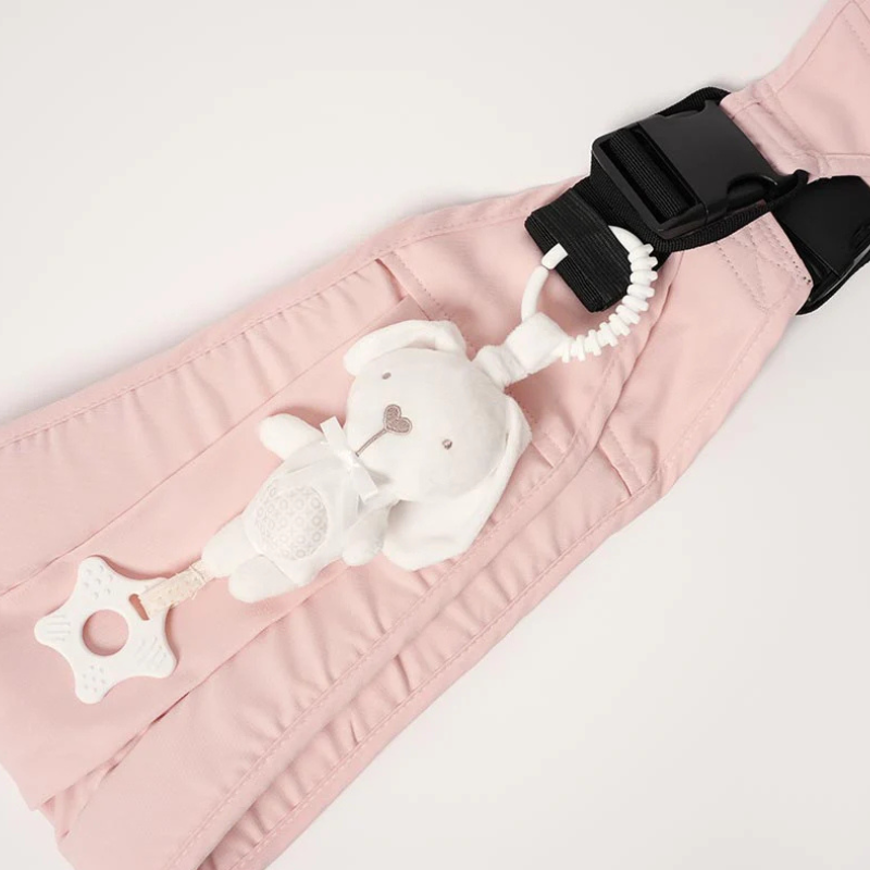 Doudou lapin blanc fixé sur un porte-bébé rose avec attache sécurisée et anneau de dentition, idéal pour le portage
