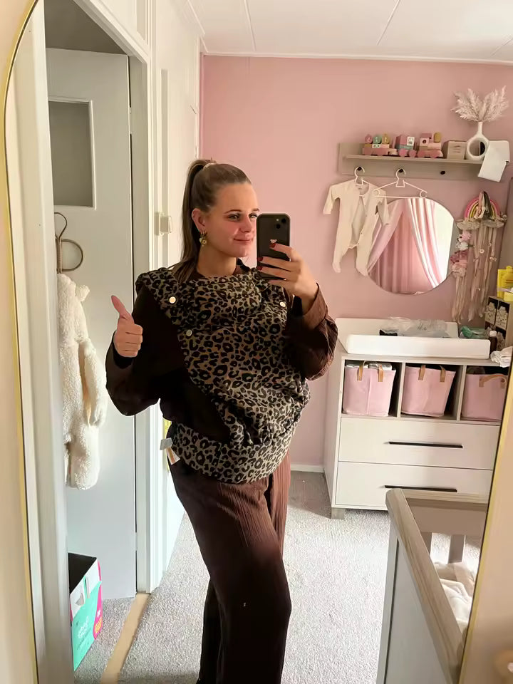 Maman portant son porte-bébé physiologique HelloBiboo, portage confortable et sécurisé en intérieur.