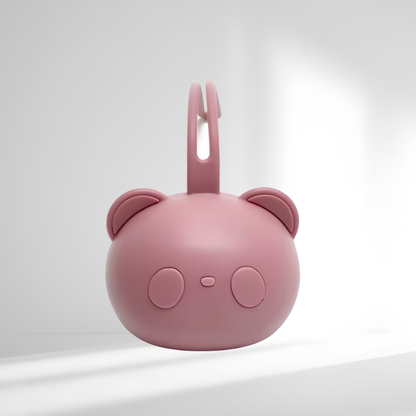 Porte-tétine en silicone rose en forme d’ourson, présenté sur un fond lumineux