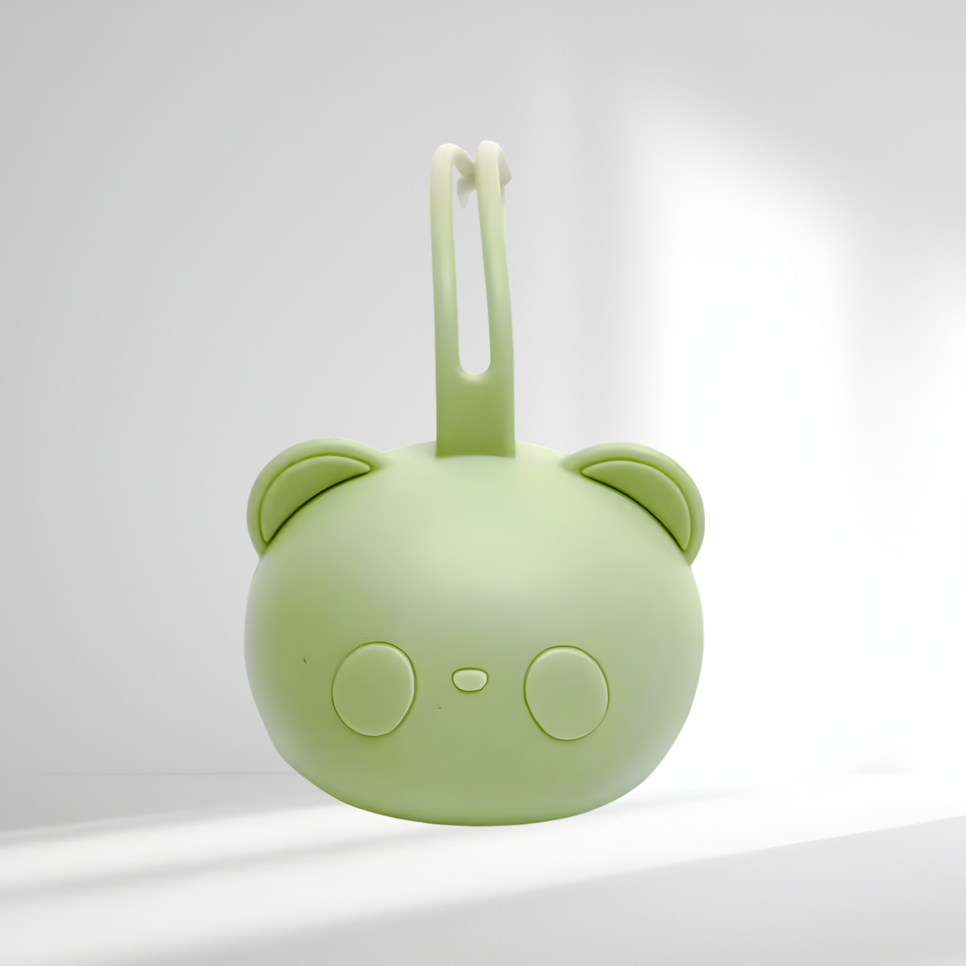 Porte-tétine en silicone vert en forme d’ourson, présenté sur un fond lumineux